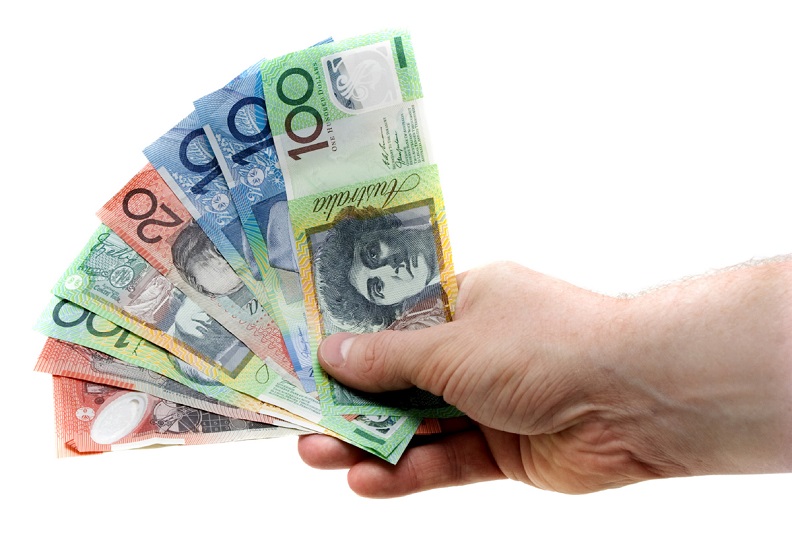 A Hand Holding A Wad Of Australian Banknotes